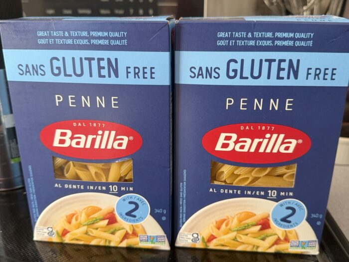 Two boxes of Barilla Gluten-Free Penne on a kitchen stove before testing.